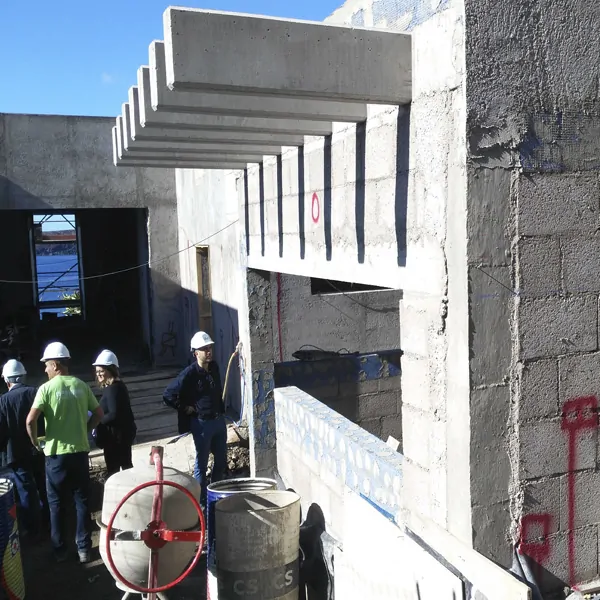 una mujer blanca arquitecta y tres hombres blancos arquitecto, aparejador y operario en obra de construcción de vivienda unifamiliar